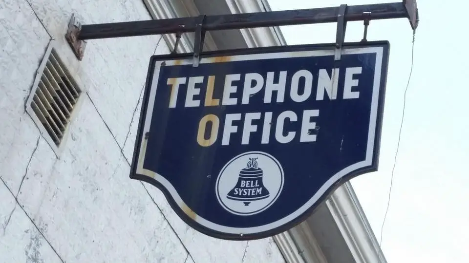A vintage blue sign of the telephone office of Bell System