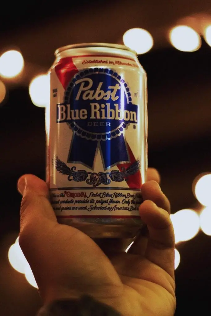 A hand with the Pabst Blue Ribbon Beercan