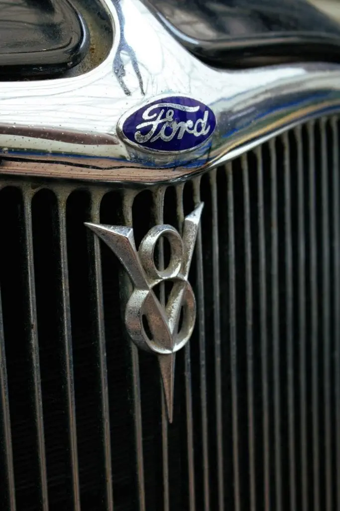 The famous blue Ford logo at the bonnet of a car.